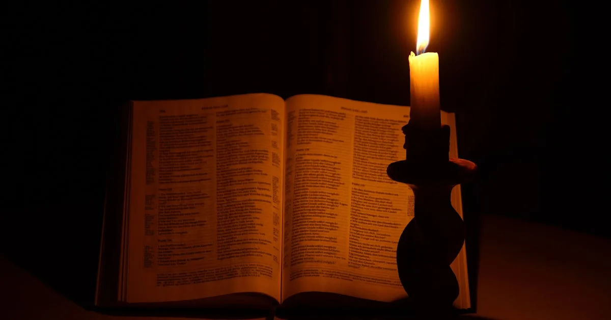 Livro aberto iluminado por uma vela acesa, representando a luz da fé e o caminho do perdão