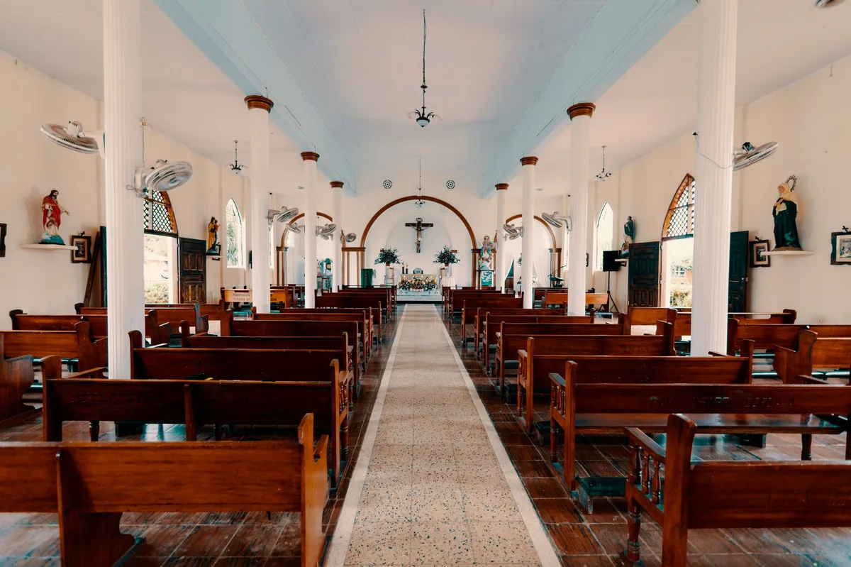 Cruz de madeira dentro de uma igreja católica iluminada
