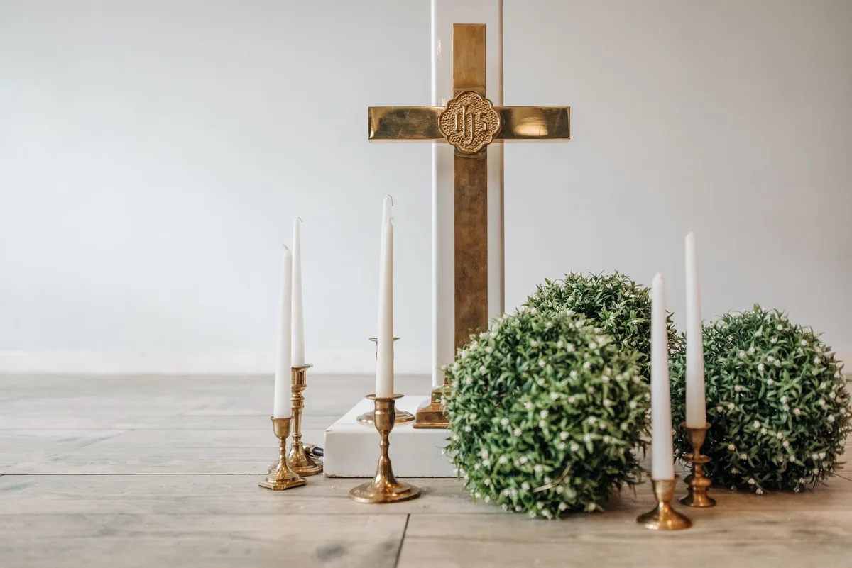 Cruz de madeira sobre altar de igreja, simbolizando a devoção da Via-Sacra