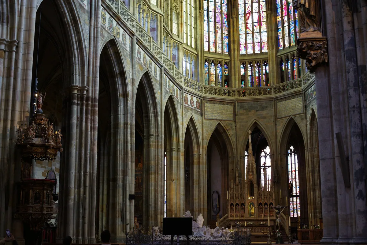 Interior de catedral com vitrais coloridos e arquitetura ornamentada