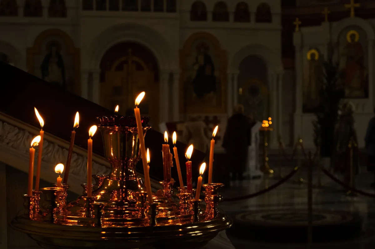 Velas acesas em ambiente escuro, representando oração e penitência