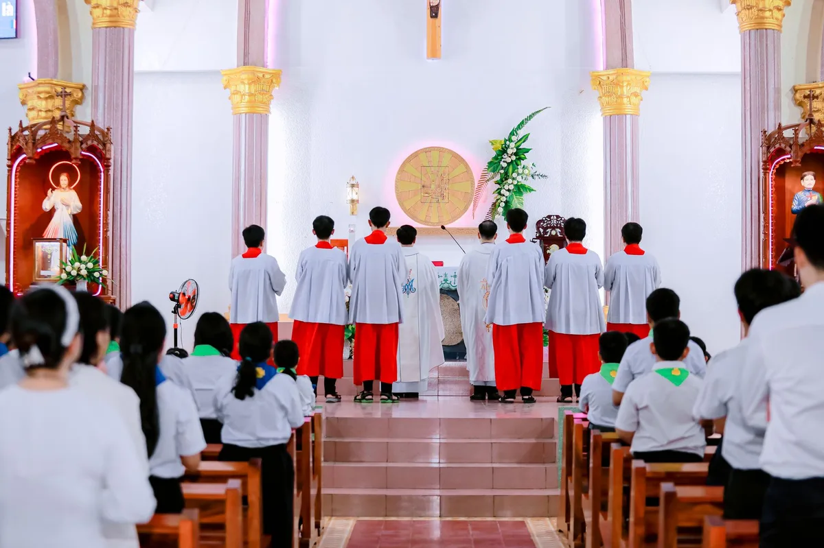 Assembleia de fiéis reunida dentro de uma igreja católica para celebração