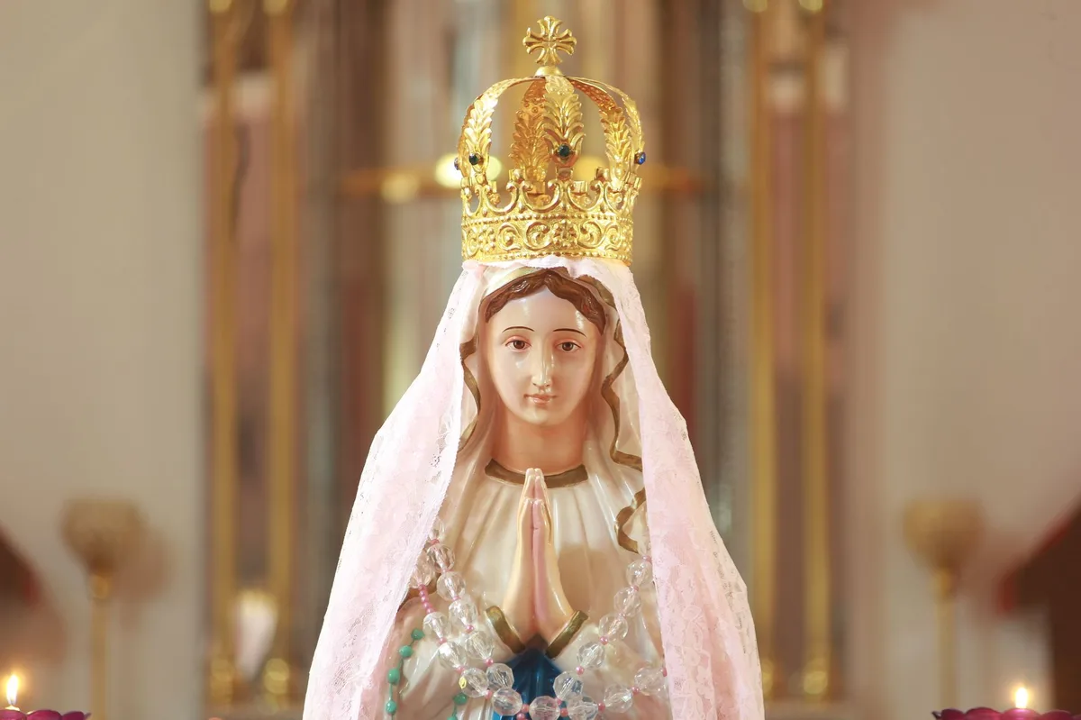 Imagem de Nossa Senhora iluminada por velas na igreja