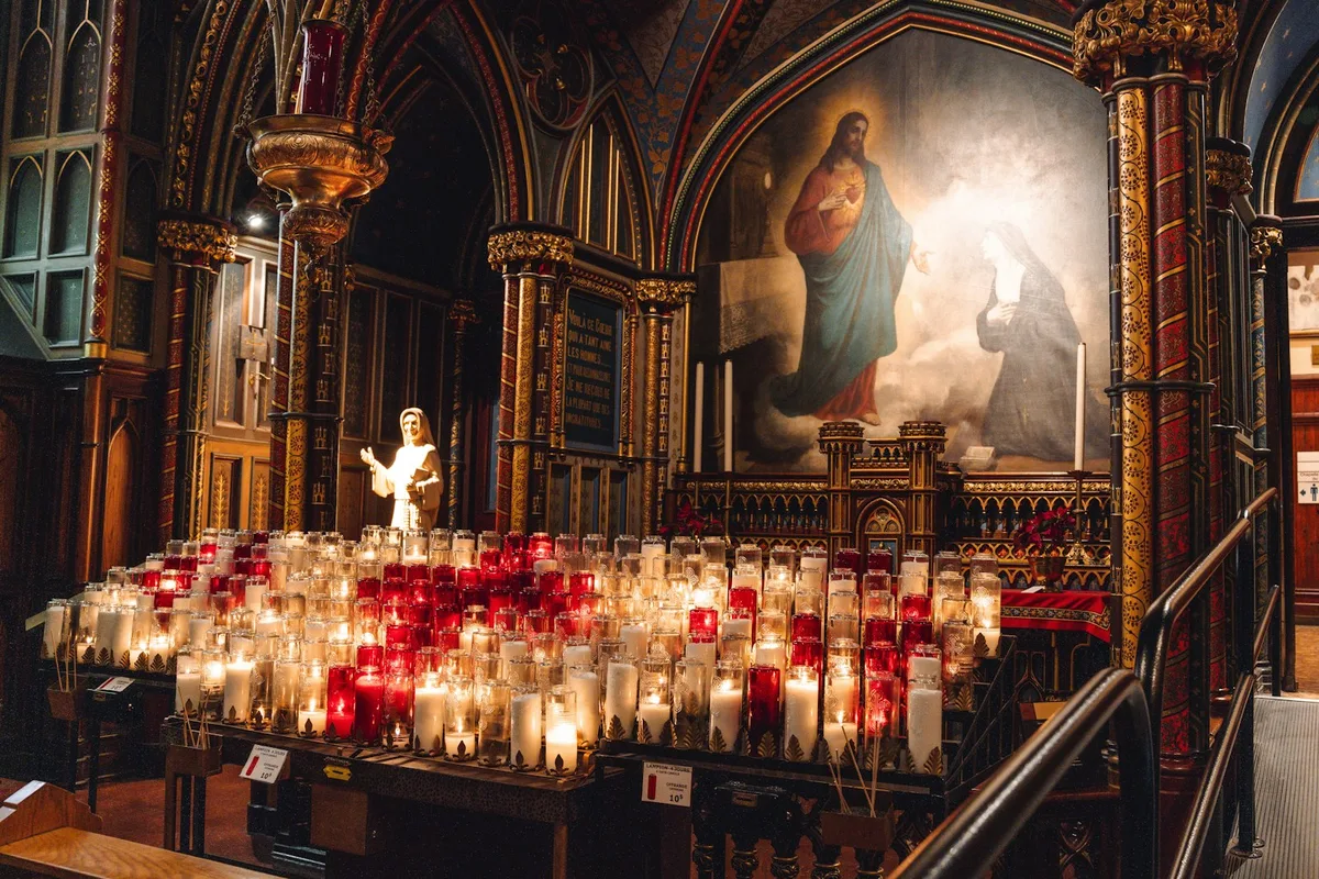 Velas votivas acesas em uma capela católica, criando um ambiente de oração e recolhimento