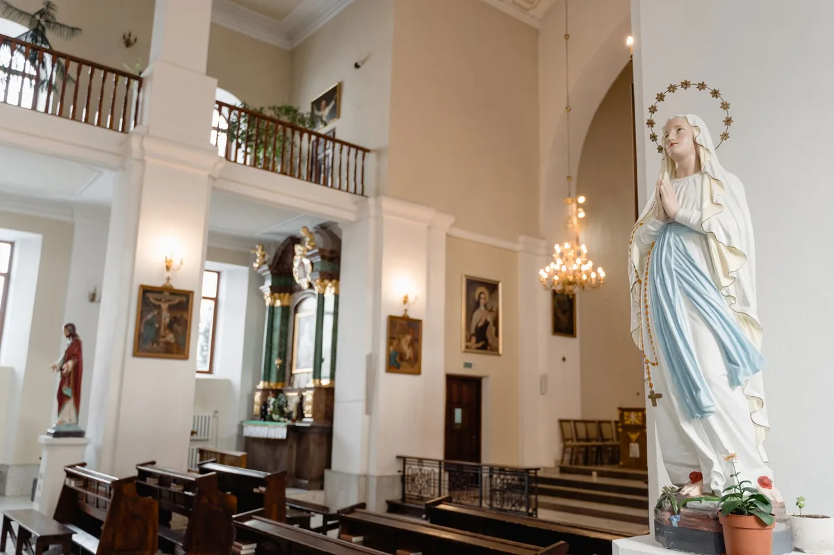 Imagem de Nossa Senhora em postura de oração dentro de uma igreja