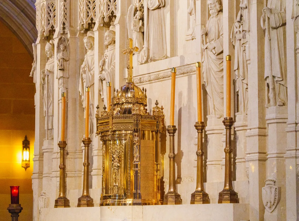 Interior de igreja católica com decoração dourada e altar ao fundo