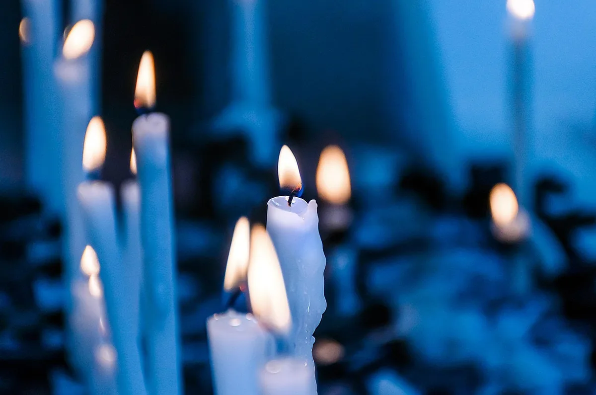 Velas acesas iluminando o ambiente escuro, representando a proteção espiritual da oração