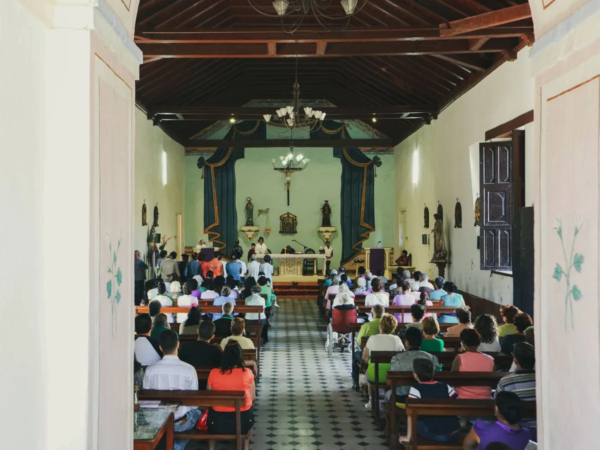 Assembleia de fiéis reunida na igreja católica em oração comunitária