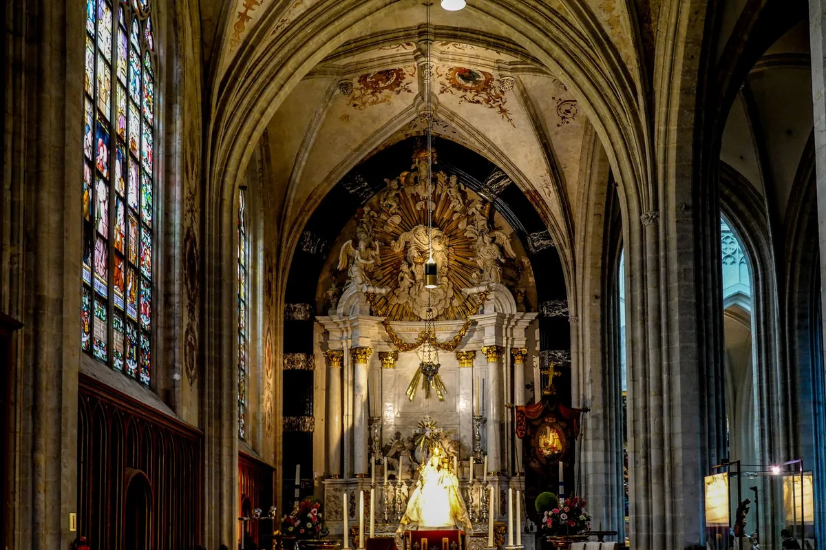 Interior de catedral com vitrais coloridos e altar ao fundo