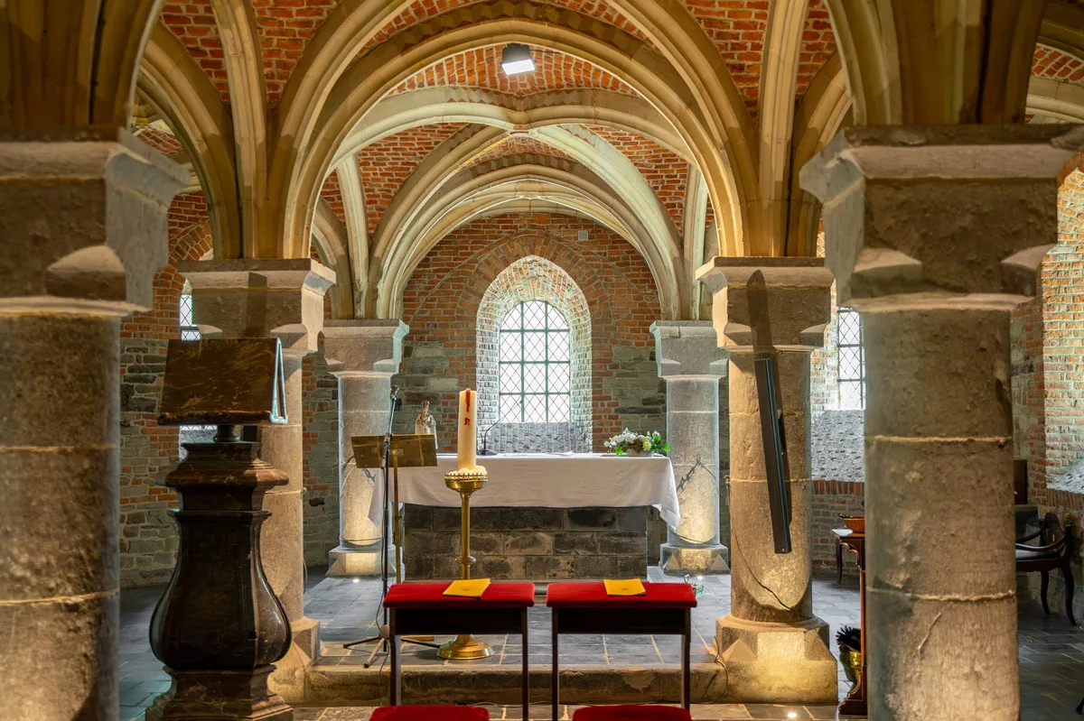 Interior de igreja antiga com decoração que remete à simplicidade franciscana