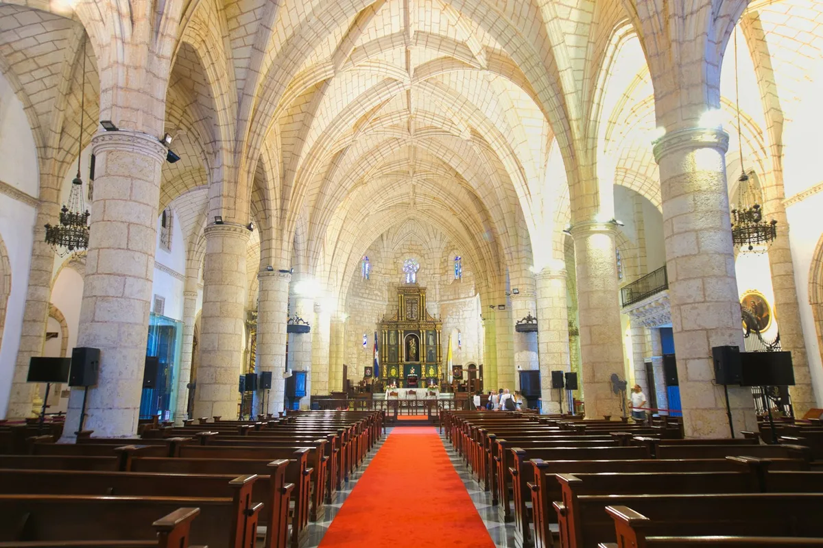 Interior de catedral católica com fiéis reunidos, representando a unidade da Igreja
