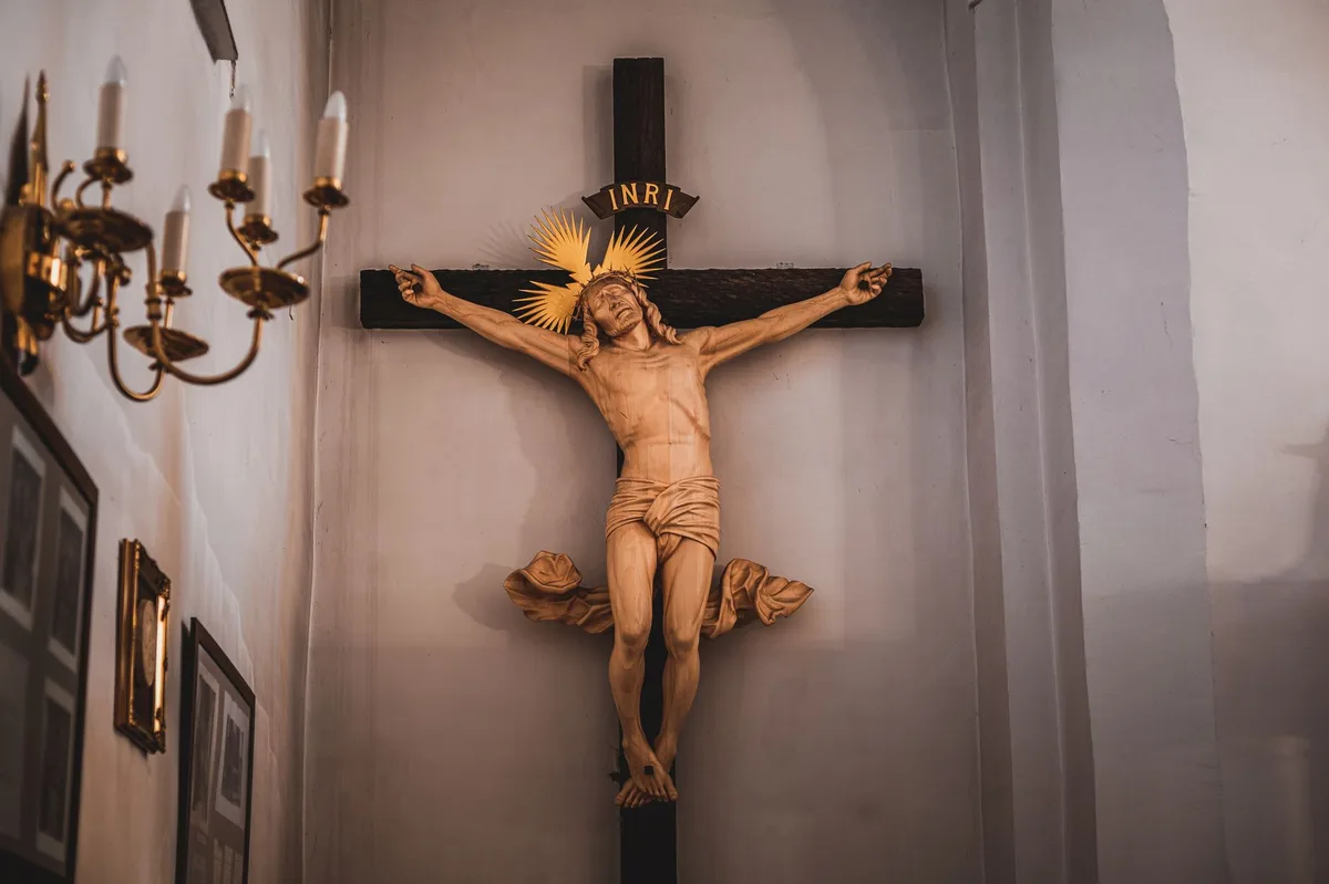 Cruz de madeira em uma igreja, símbolo do sofrimento e redenção de Cristo